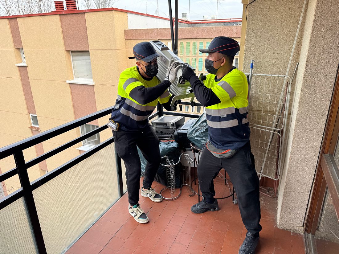 Operarios de Vacía Tu Piso subiendo electrodomésticos al piso en Madrid